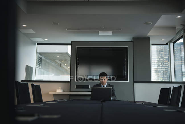 Деловой человек с ноутбуком в конференц-зале — стоковое фото
