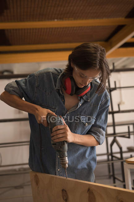 Handwerkerin mit Bohrmaschine in Werkstatt. — Stockfoto