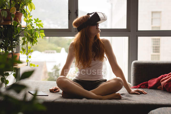 Женщина с гарнитурой виртуальной реальности дома — стоковое фото