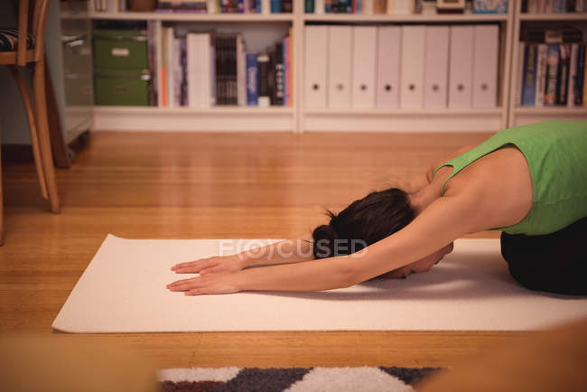 Woman performing yoga in living room at home — Stock Photo