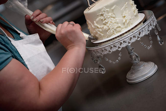 Close-up of woman preparing cake in bakery — Stock Photo
