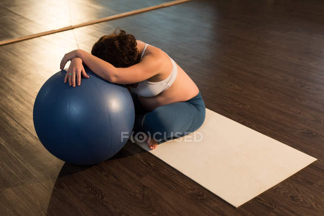 Femme enceinte assise avec ballon d'exercice — Photo de stock