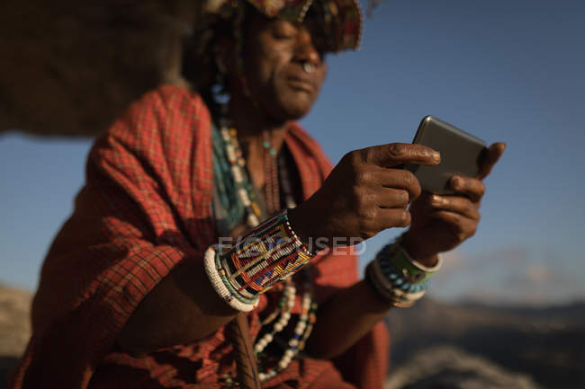 Maasai homem em roupas tradicionais usando telefone celular — Fotografia de Stock