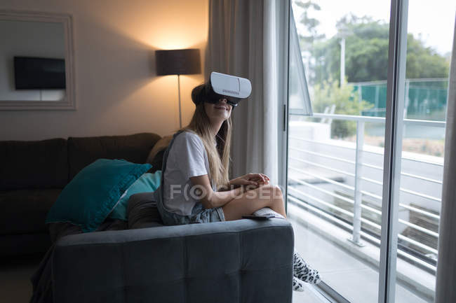 Женщина, использующая гарнитуру виртуальной реальности в гостиной дома. — стоковое фото
