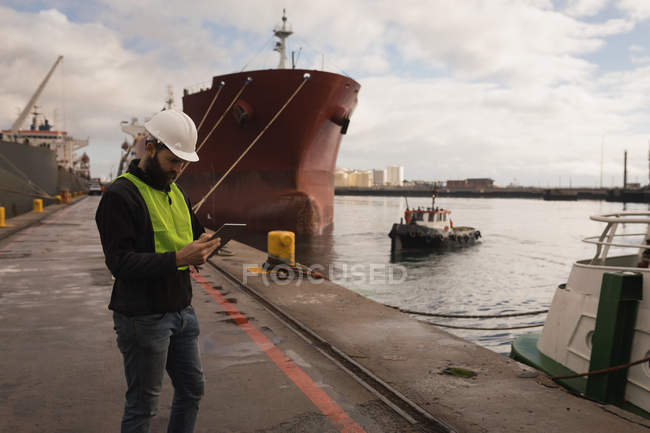 Operaio portuale che utilizza tablet digitale nel cantiere navale — Foto stock