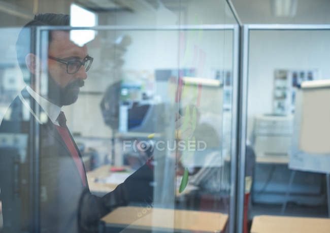 Dirigeant d'entreprise regardant des notes collantes dans le bureau — Photo de stock