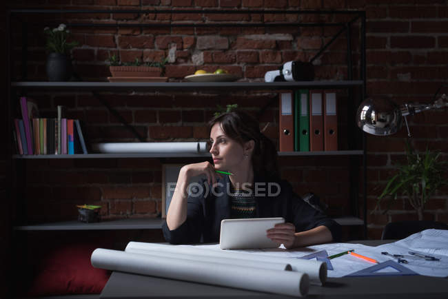 Продумана жінка-виконавця за допомогою цифрового планшета в офісі — стокове фото