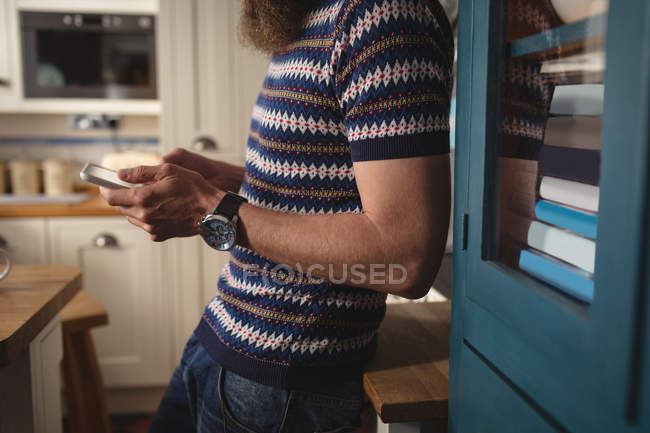 Close-up de homem forro na prateleira ao usar o telefone móvel — Fotografia de Stock
