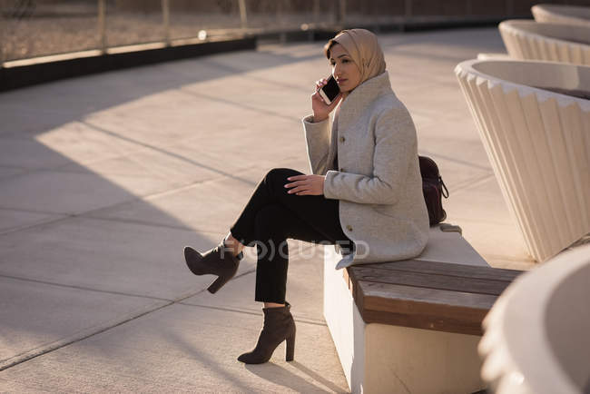 Femme en hijab parlant sur un téléphone mobile par une journée ensoleillée — Photo de stock