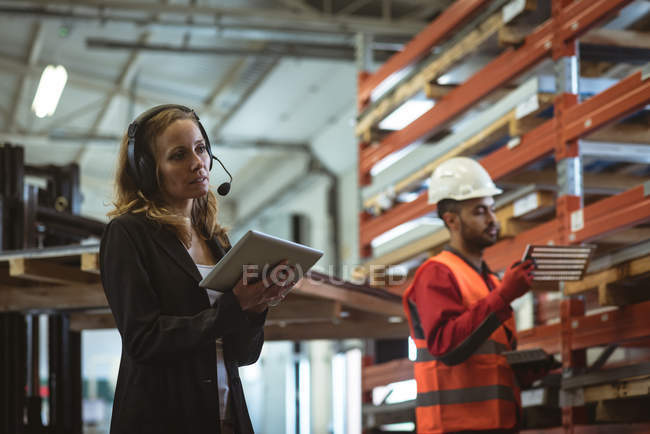 Trabalhadora feminina usando tablet digital na fábrica — Fotografia de Stock