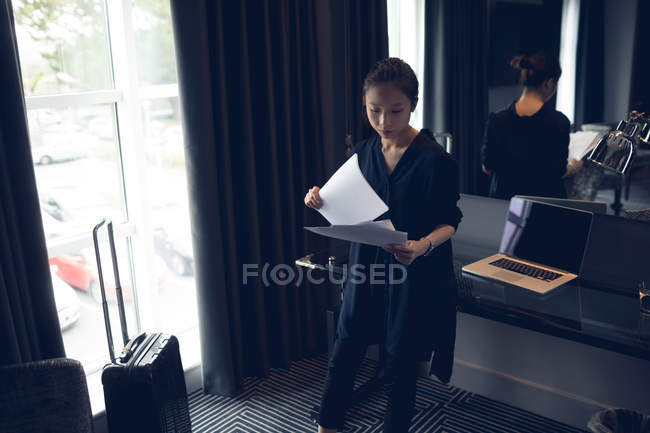 Frau liest Dokumente im Hotelzimmer — Stockfoto