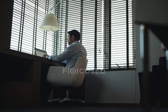 Uomo d'affari che utilizza il computer portatile a tavola in hotel — Foto stock