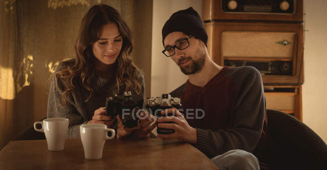 Couple reviewing pictures on vintage camera at home — Stock Photo