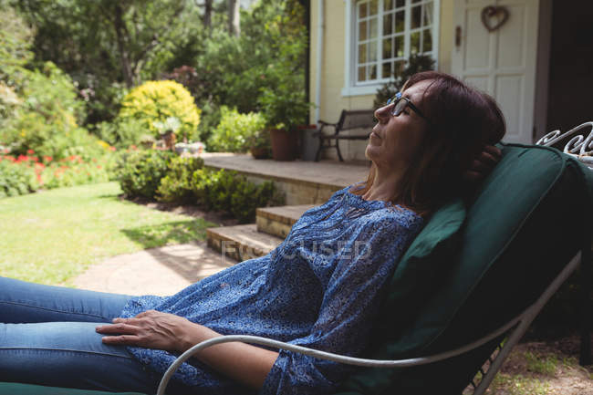 Frau entspannt sich an einem sonnigen Tag im Sessel — Stockfoto