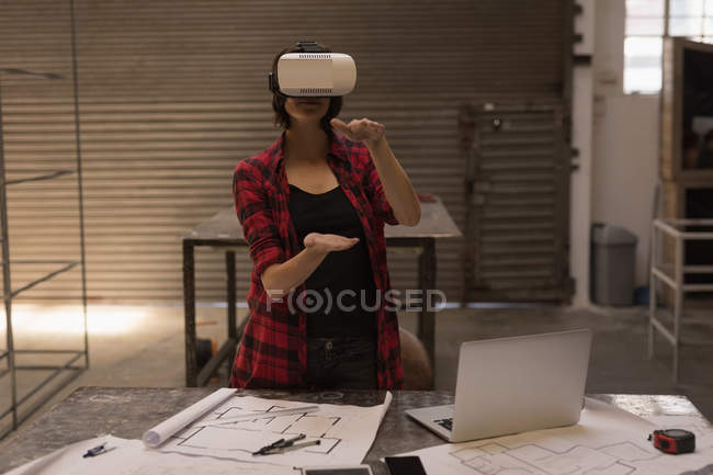 Female engineer using virtual reality headset in workshop. — Stock Photo