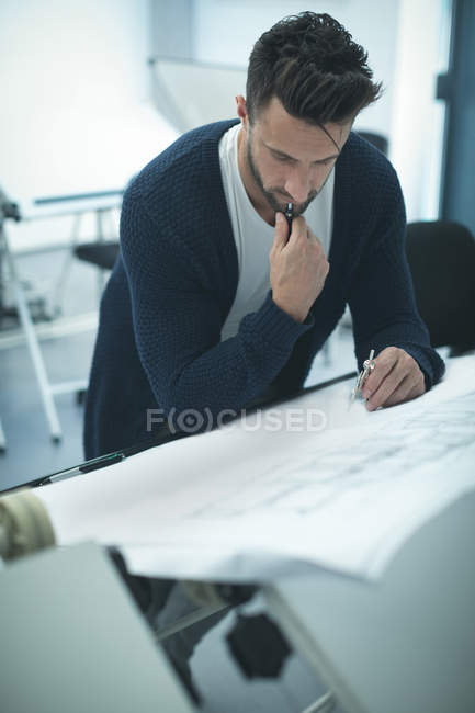 Executive working on blueprint in modern office — Stock Photo