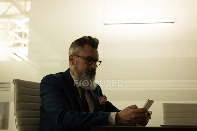 Керівник бізнесу за допомогою мобільного телефону в офісі — стокове фото