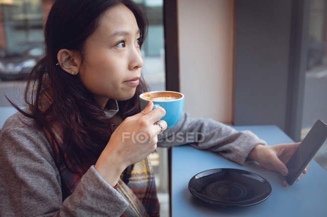 Donna premurosa che prende un caffè a tavola in mensa — Foto stock