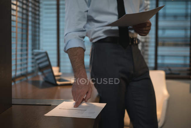 Imagen recortada del hombre de negocios verificando documentos en la habitación del hotel - foto de stock