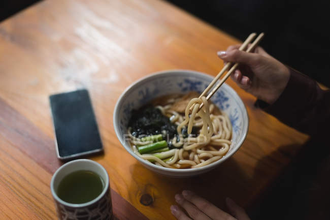 Close-up of woman having noodles in restaurant — Stock Photo