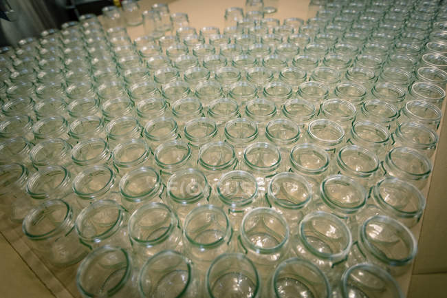 Primer plano de frascos de vidrio vacíos en la línea de producción - foto de stock