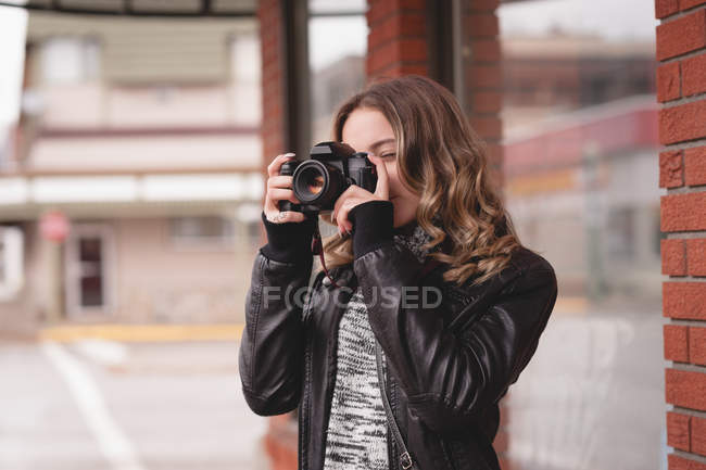 Chica atractiva tomando fotos con cámara digital - foto de stock
