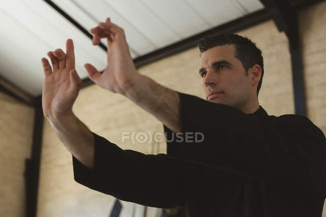 Боец кунг-фу, практикующий боевые искусства в фитнес-студии . — стоковое фото