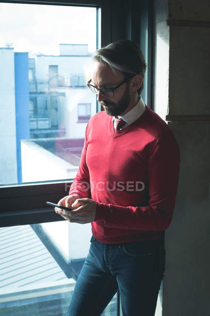 Homme exécutif utilisant le téléphone mobile dans le bureau moderne — Photo de stock