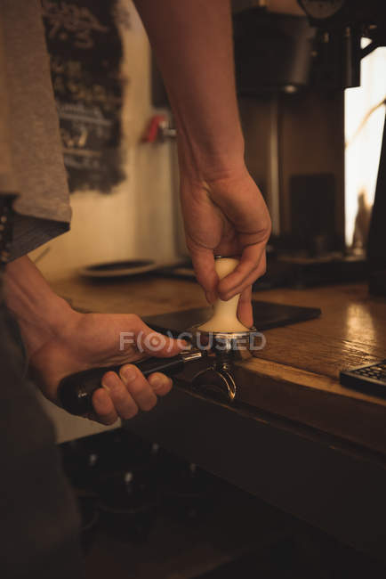Mid section of barista preparing coffee at cafeteria counter — Stock Photo