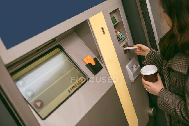 Mulher tomando bilhete da máquina na plataforma ferroviária — Fotografia de Stock