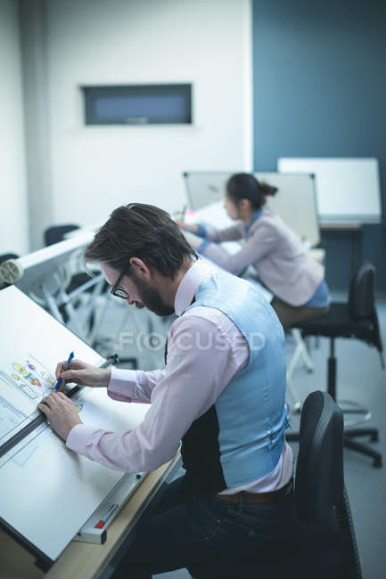 Executive working on blueprint in modern office — Stock Photo