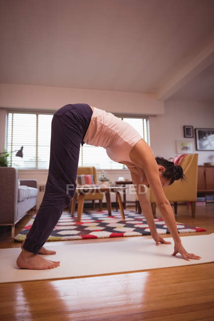 Woman performing yoga in living room at home — Stock Photo