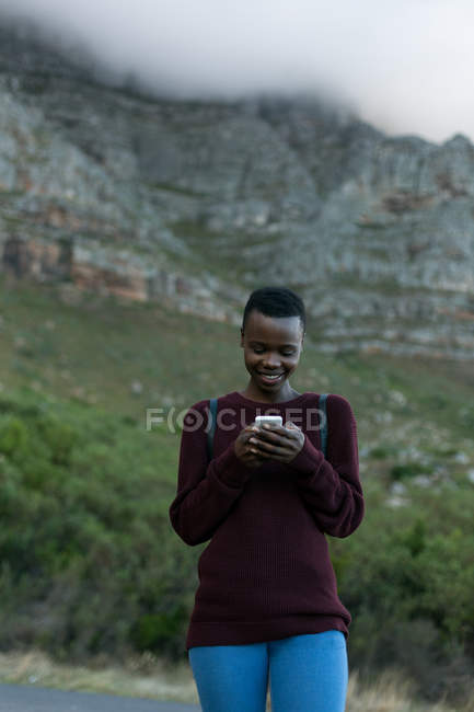 Young woman using mobile at countryside — Stock Photo