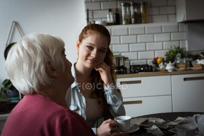 Grandmother and grand daughter interacting with each other at home — Stock Photo