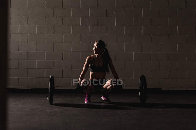 Mujer en forma de ejercicio con barra en el estudio - foto de stock