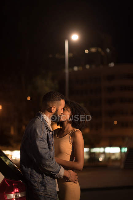 Couple romantique s'embrassant sur la route la nuit — Photo de stock