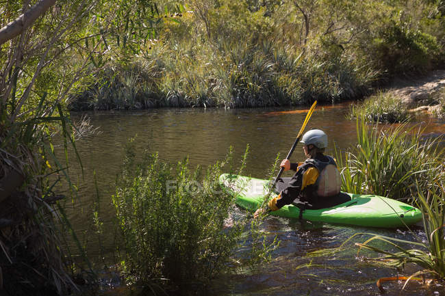 Mujer kayak en la vegetación del río . - foto de stock