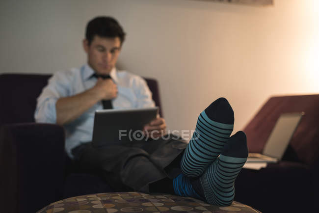 Бизнесмен, использующий цифровой планшет в спальне отеля — стоковое фото
