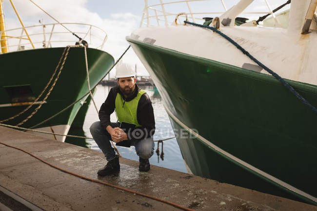 Retrato do trabalhador portuário posando perto do navio no porto — Fotografia de Stock