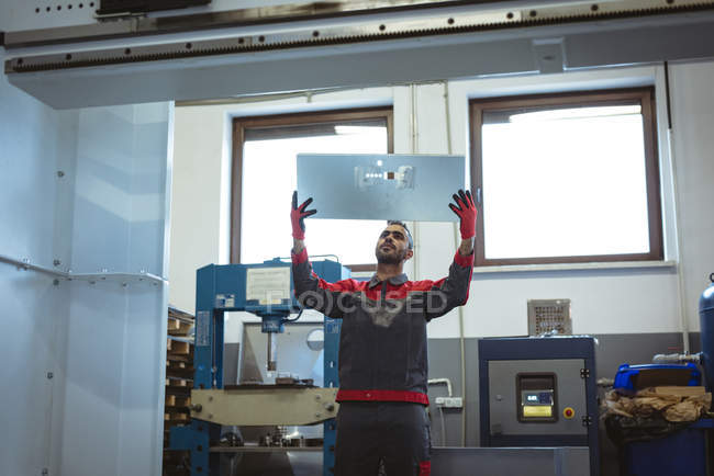 Чоловік-працівник перевіряє машину на заводі — стокове фото