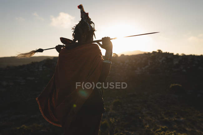 Вид ззаду чоловік Масаї стоїть з палицею на сільській місцевості — стокове фото