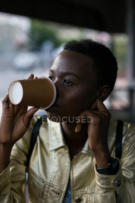 Jeune femme prenant un café dans un café extérieur — Photo de stock