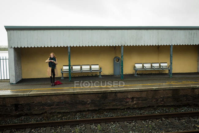 Mulher bonita na plataforma de trem em tempo sombrio — Fotografia de Stock