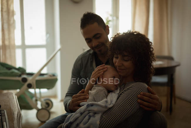 Parents holding their baby in living room at home — Stock Photo