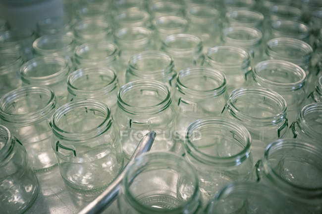 Vista de cerca de frascos de vidrio vacíos en la línea de producción - foto de stock