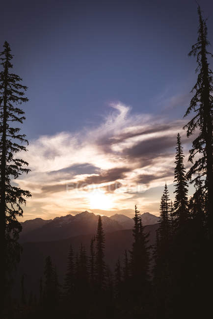 Sole che sorge sulla catena montuosa rocciosa con le nuvole che passano — Foto stock