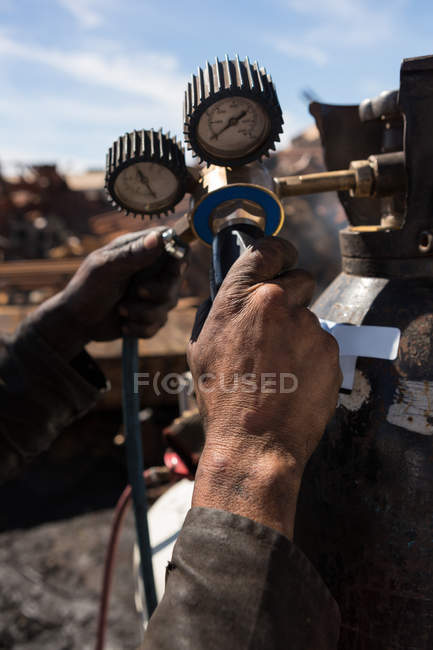 Close-up of worker operating the gas cylinder in scrapyard — Stock Photo