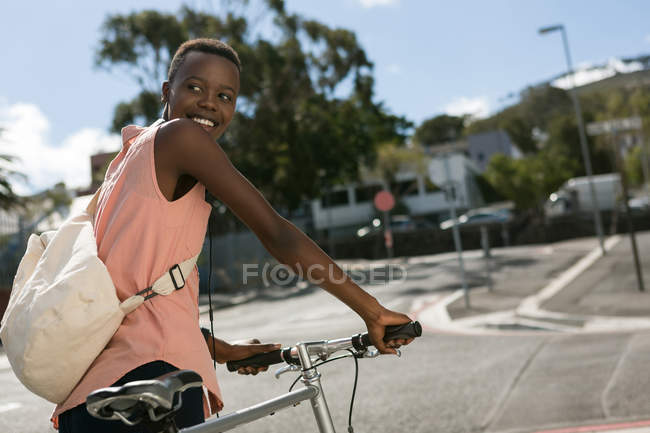 Mulher feliz andando com bicicleta na rua da cidade — Fotografia de Stock