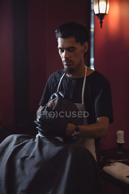 Barbeiro limpando o rosto dos clientes com toalha na barbearia — Fotografia de Stock