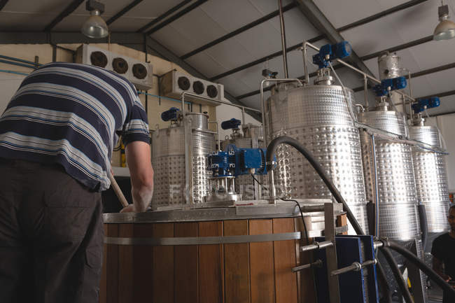 Vista posteriore del lavoratore maschile che mescola gin in distilleria in fabbrica — Foto stock